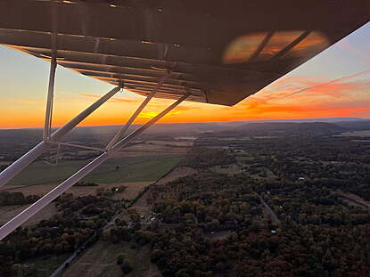 a beautiful sunset from the air in a classic taildragger airplane