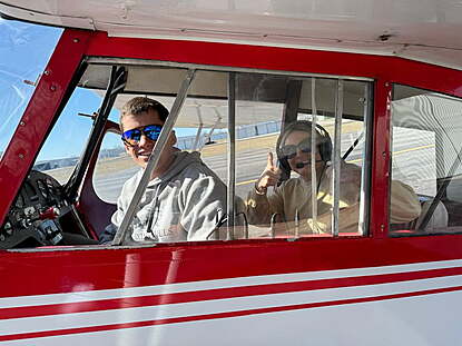 flight instructor and tailwheel student with happy smiles and thumbs up after a first lesson